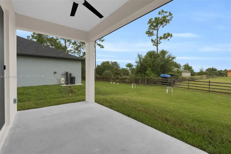 Open lanai with ceiling fan overlooking the backyard.
