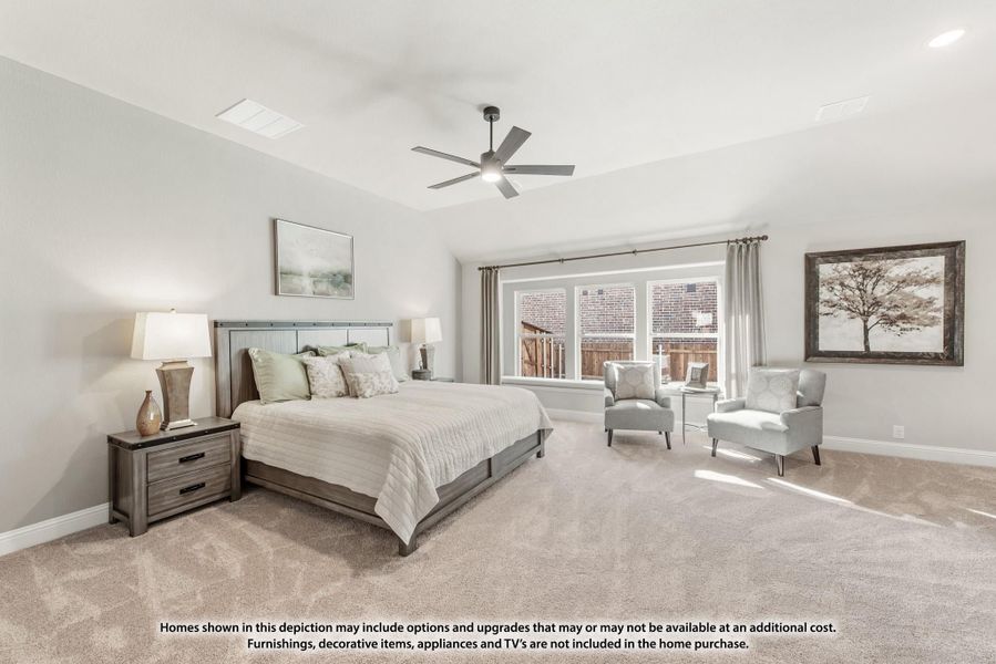 Spacious master bedroom with vaulted ceiling, ceiling fan, carpet flooring, and a seating area near large windows