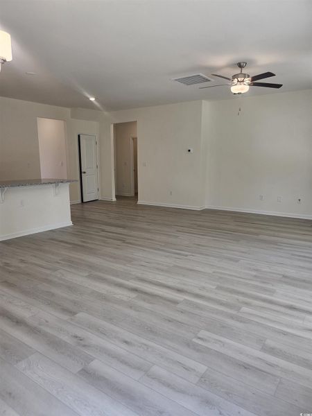 Unfurnished living room with LVP floors and ceiling fan