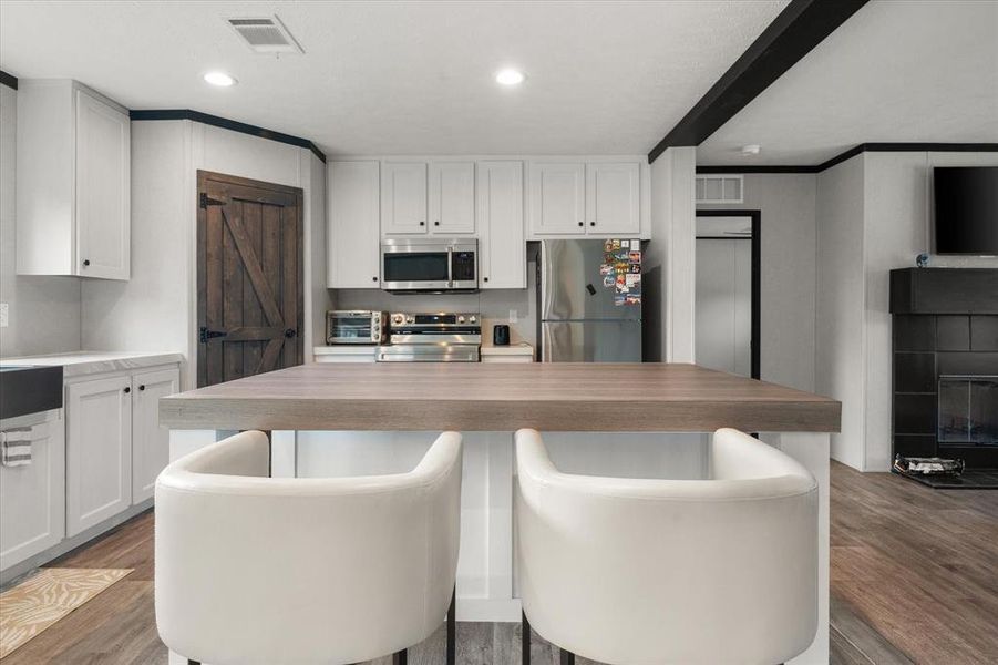 Open-concept kitchen featuring an island and built-in stainless steel microwave Open-concept kitchen featuring an island and built-in stainless steel microwave