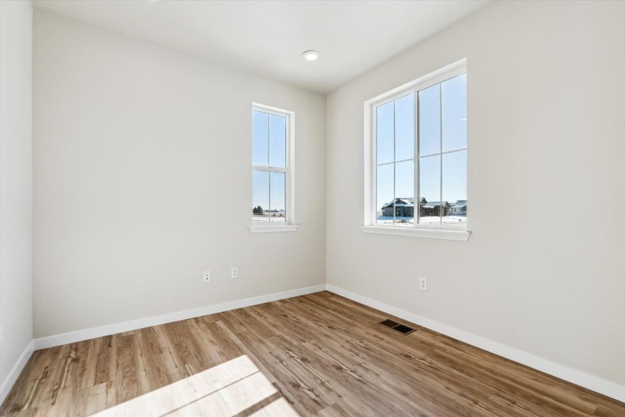 A room with a wood floor and windows.