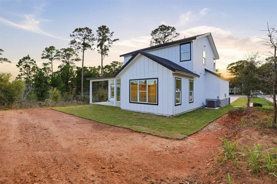Back of house featuring a patio, board and batten siding, and a yard