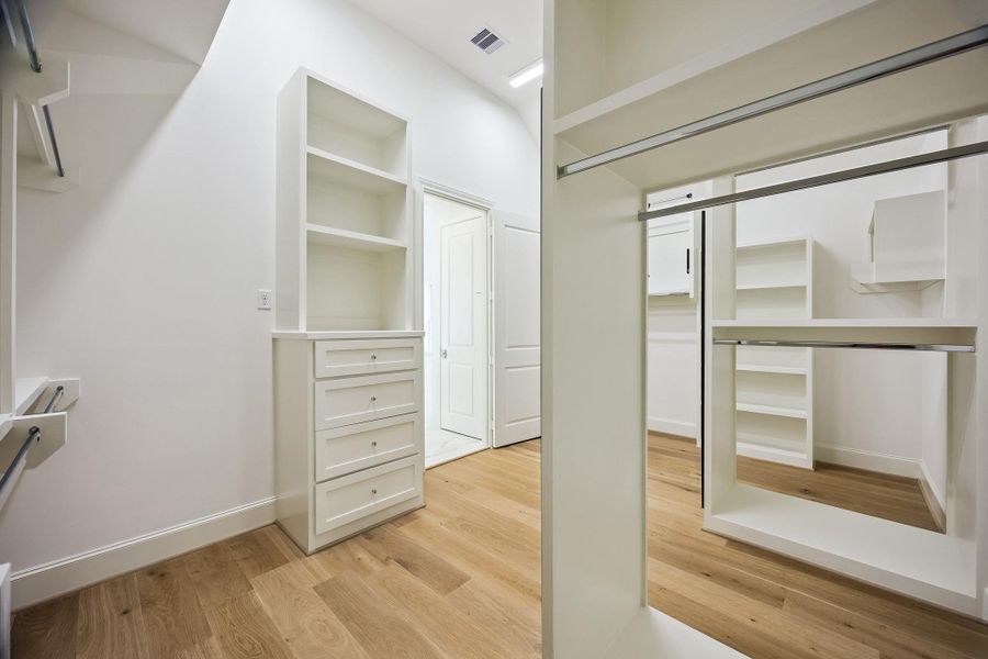 Custom primary closet offers thoughtfully designed built-ins and abundant storage.