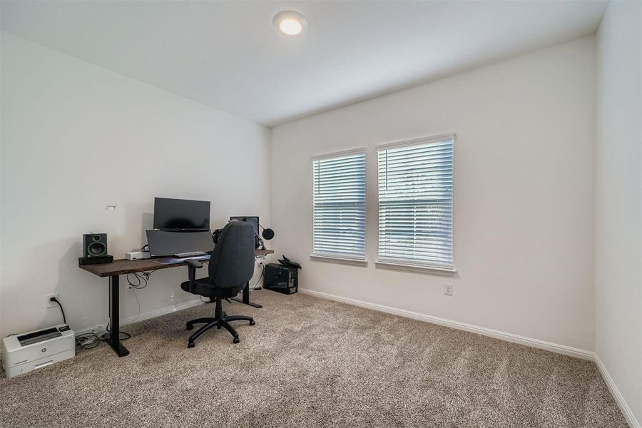 Carpeted office space with baseboards