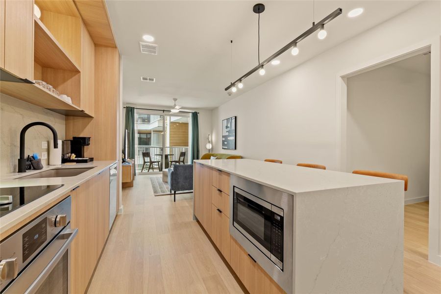 Clean lines and warm wood cabinetry define this modern open kitchen layout.