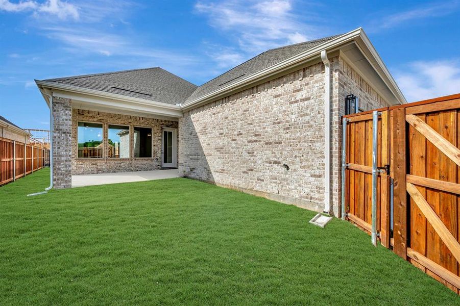 Back of property with a patio area, a shingled roof, brick siding, and a gate Back of property with a patio area, a shingled roof, brick siding, and a gate