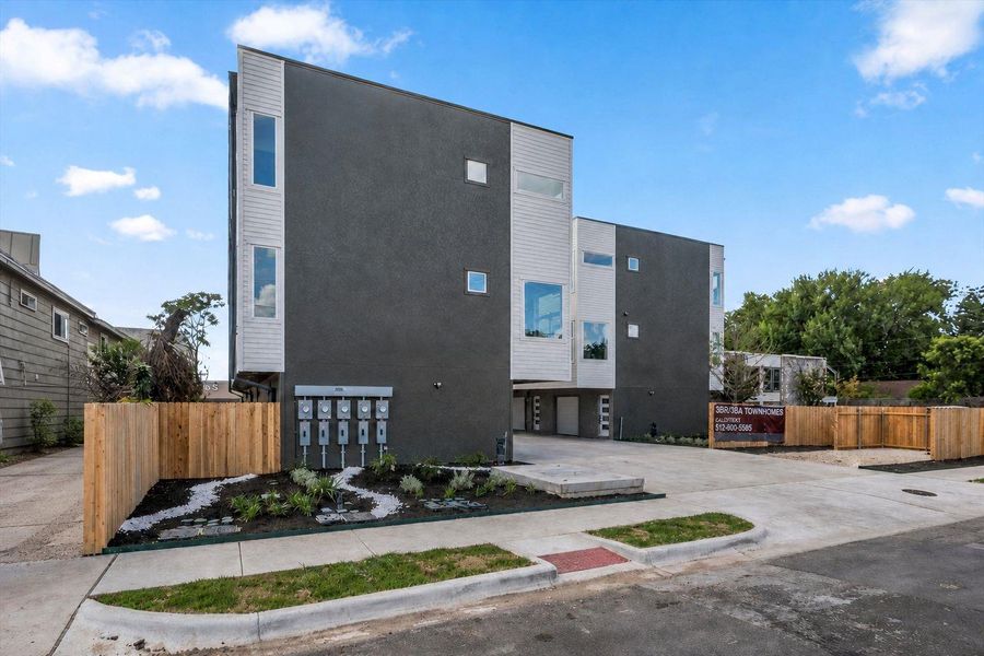 Modern townhomes showcasing sleek lines, bold charcoal and white siding, and well-maintained front landscaping. Modern townhomes showcasing sleek lines, bold charcoal and white siding, and well-maintained front landscaping.