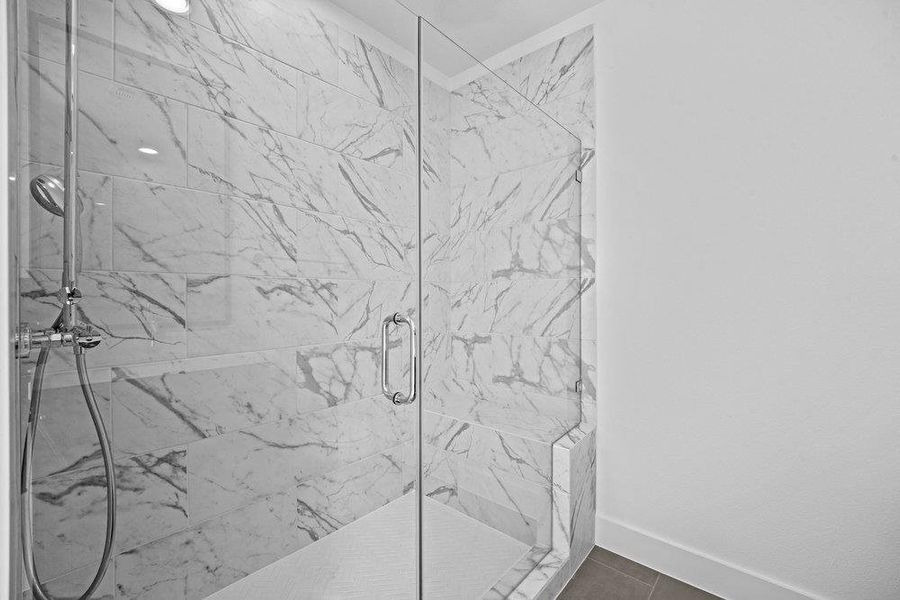 Bathroom featuring a marble finish shower and baseboards