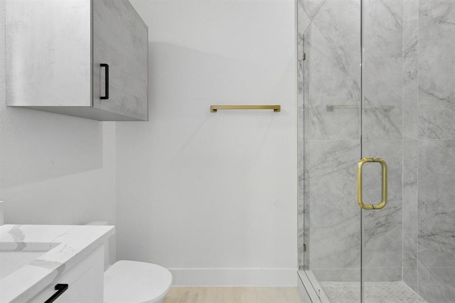 Full bathroom with a marble finish shower and vanity