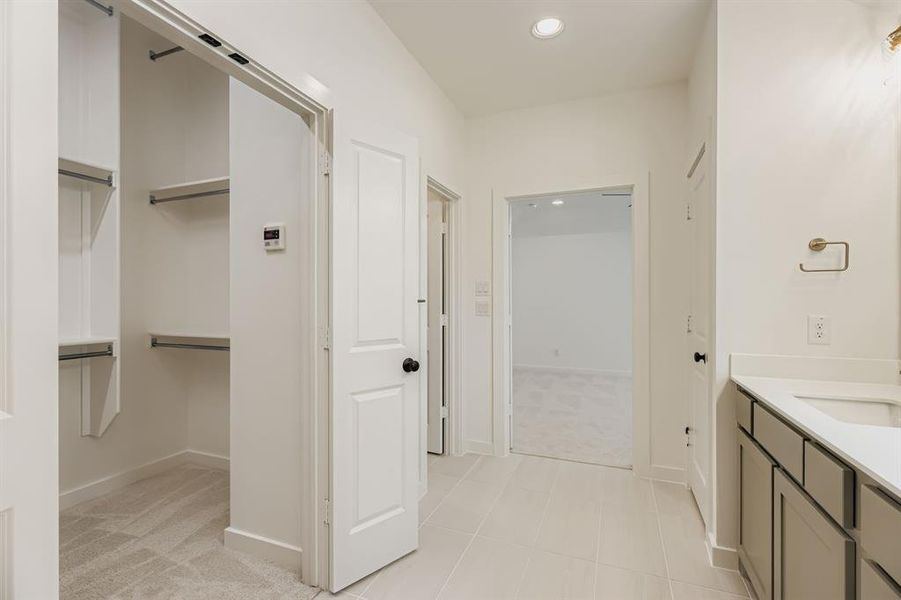 Bathroom featuring vanity, recessed lighting, and a walk in closet