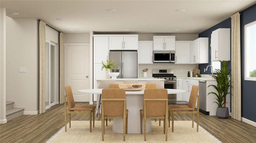 Kitchen featuring appliances with stainless steel finishes, light countertops, white cabinetry, a breakfast bar area, and light wood-style flooring Kitchen featuring appliances with stainless steel finishes, light countertops, white cabinetry, a breakfast bar area, and light wood-style flooring