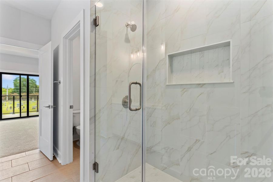 Luxurious primary shower featuring full tile surround for a clean, elevated look. Luxurious primary shower featuring full tile surround for a clean, elevated look.