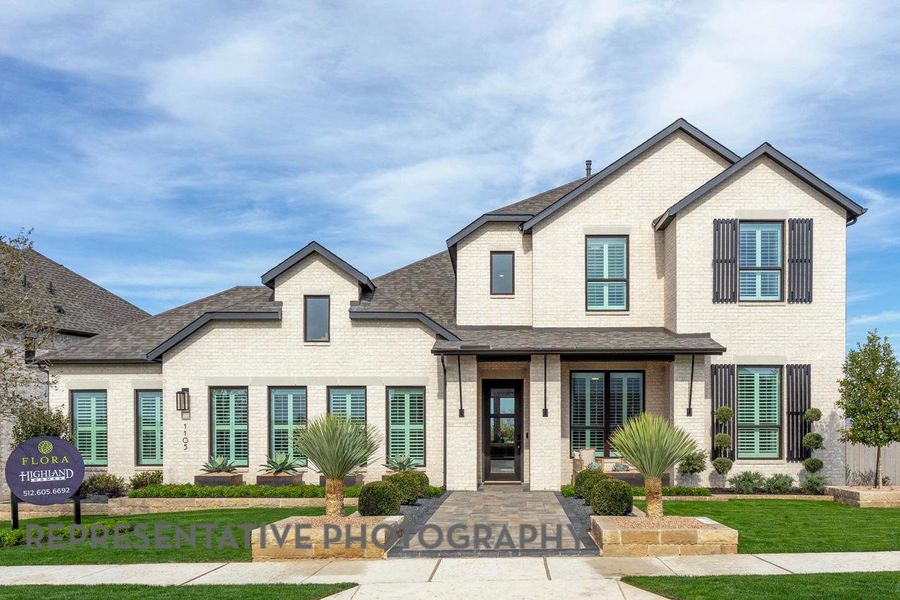 View of front facade featuring brick siding, a shingled roof, and a front yard