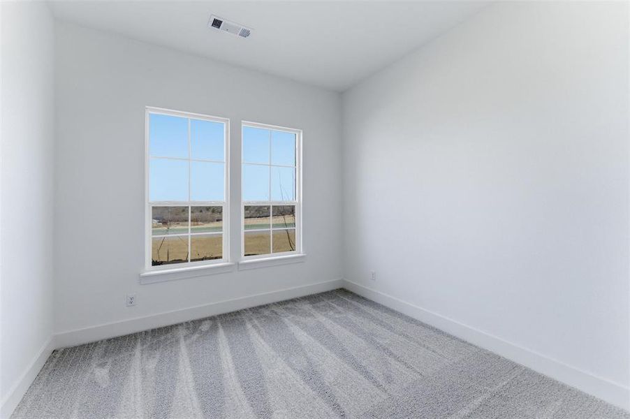 Carpeted spare room with baseboards