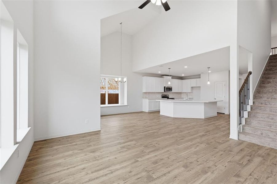 Expansive great room featuring wood-finish flooring, vaulted ceilings, and large windows