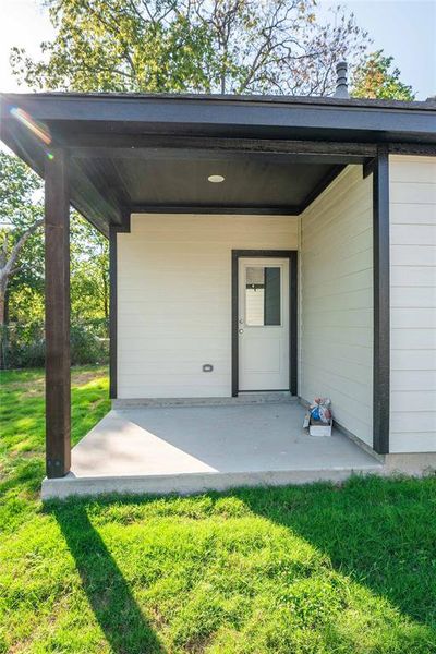 View of exterior entry featuring a yard