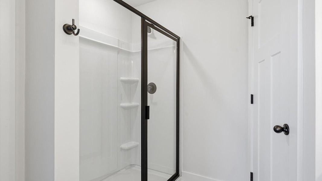Spacious and modern primary bathroom with walk-in shower and first-class double vanity setup