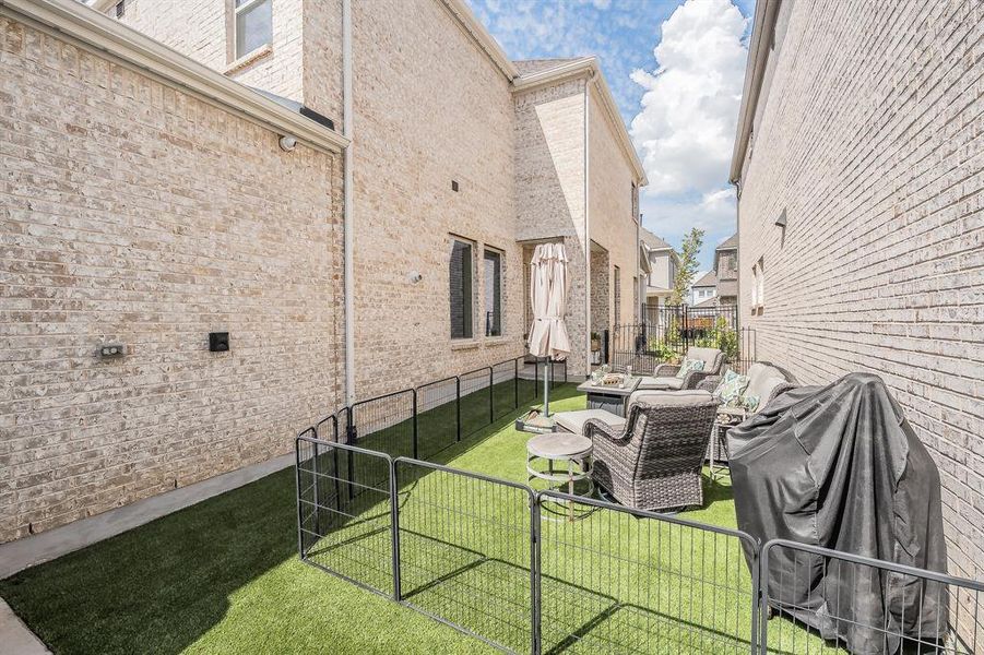 View of home's exterior featuring an outdoor hangout area, a patio, brick siding, and a gate
