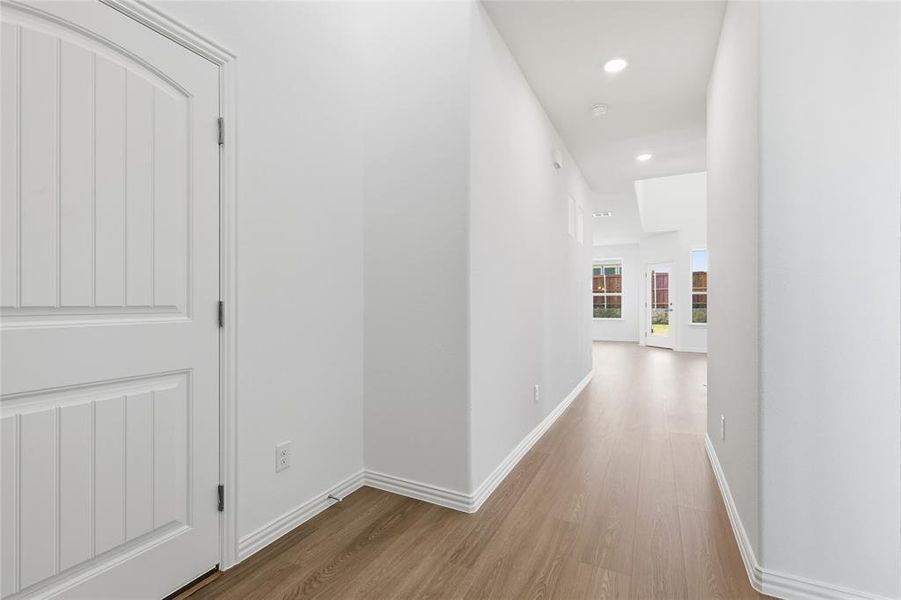 Corridor with light wood finished floors and recessed lighting