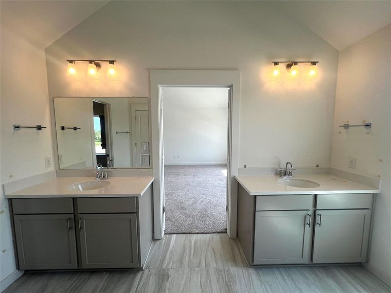 Bathroom with vanity and high vaulted ceiling