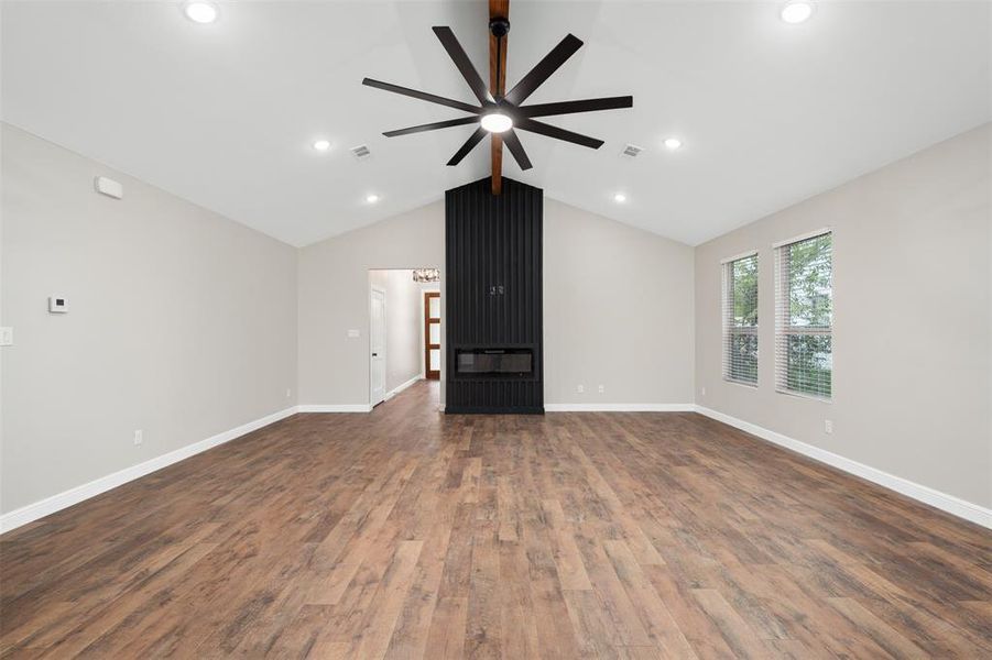 Unfurnished living room with dark wood-type flooring and a ceiling fan
