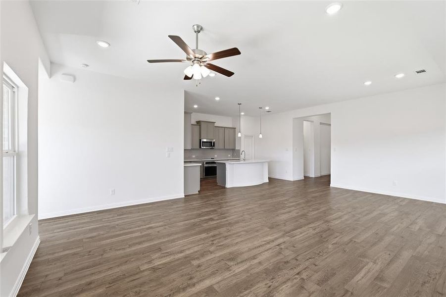 Spacious interior featuring wood-finish flooring, recessed lighting, and a ceiling fan