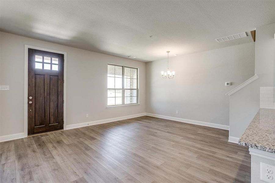 Entryway featuring light wood-type flooring and a chandelier