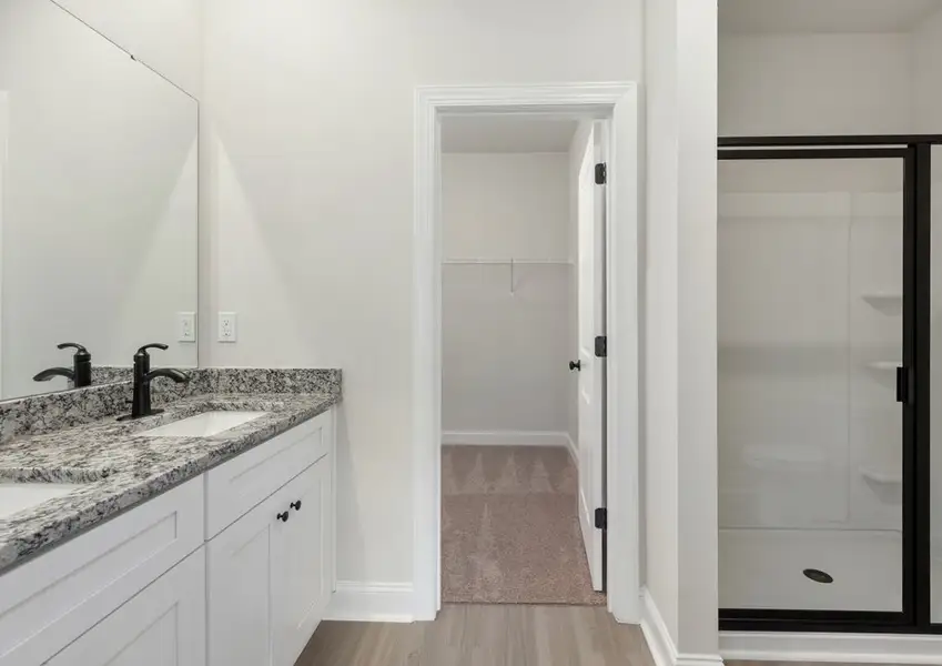 The master bathroom has a glass-enclosed shower and walk-in closet The master bathroom has a glass-enclosed shower and walk-in closet