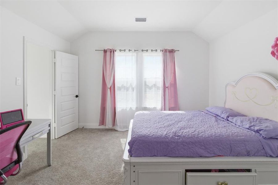 Carpeted room with a vaulted ceiling and a single window