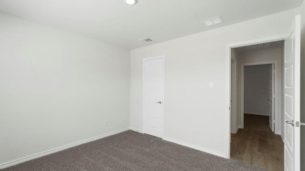 Carpeted room with light gray walls, white trim, and a flush-mounted ceiling light