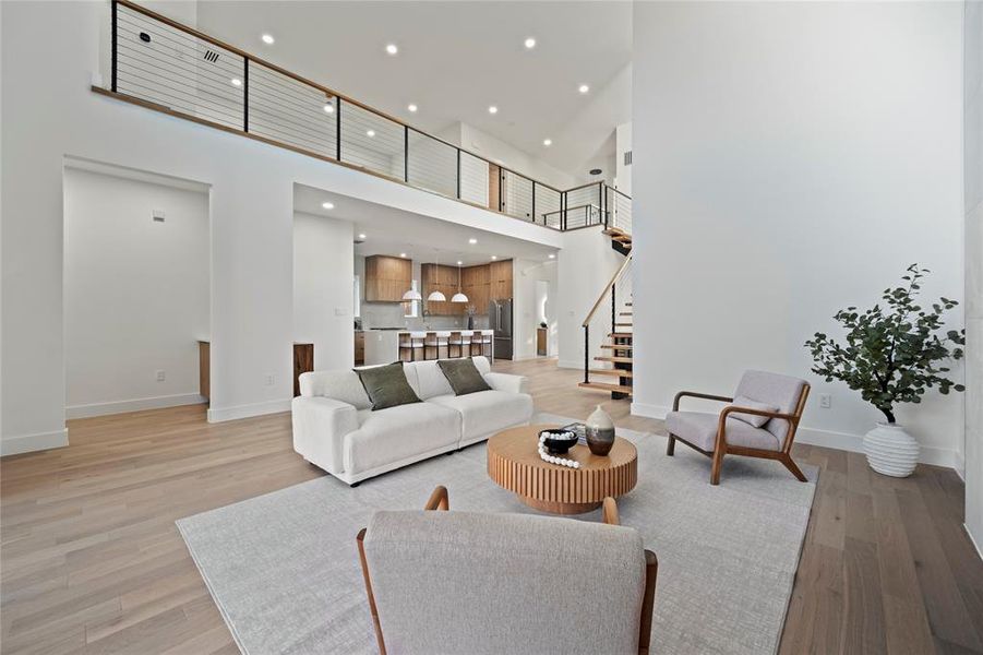 Living room featuring light hardwood / wood-style flooring and a high ceiling