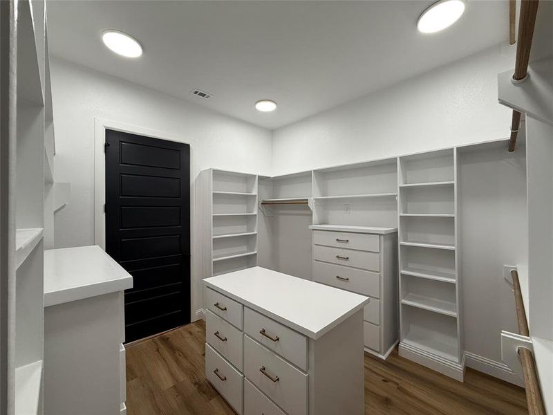 Walk in closet featuring dark wood-style floors Walk in closet featuring dark wood-style floors