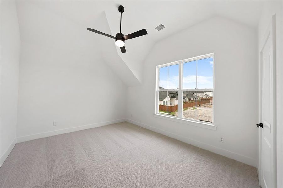 Bonus room with vaulted ceiling, light carpet, and a ceiling fan Bonus room with vaulted ceiling, light carpet, and a ceiling fan