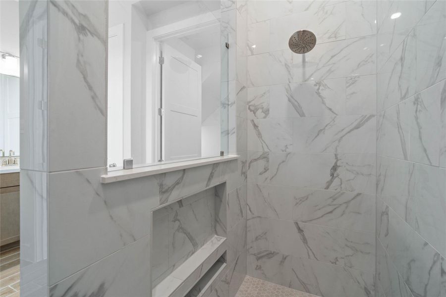 Step into luxury with this spacious, walk-in shower, a true spa-like retreat designed for relaxation and modern convenience. Featuring expansive white marble-look tiling, a sleek glass partition, and a built-in storage niche for a minimalist aesthetic. Step into luxury with this spacious, walk-in shower, a true spa-like retreat designed for relaxation and modern convenience. Featuring expansive white marble-look tiling, a sleek glass partition, and a built-in storage niche for a minimalist aesthetic.