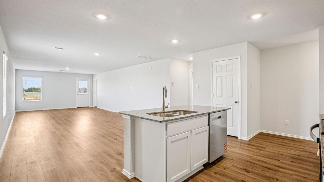 Open-concept living space featuring wood-finish flooring, recessed lighting, and white trim Open-concept living space featuring wood-finish flooring, recessed lighting, and white trim