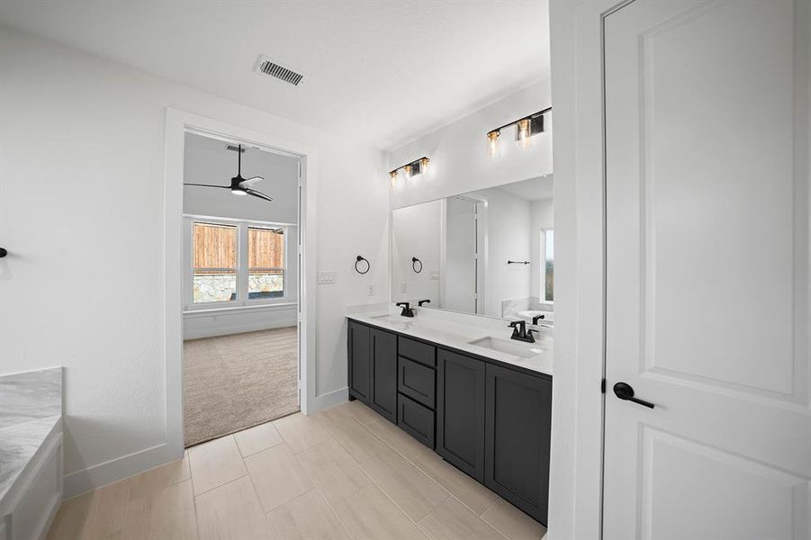 Bathroom featuring double vanity and a ceiling fan Bathroom featuring double vanity and a ceiling fan