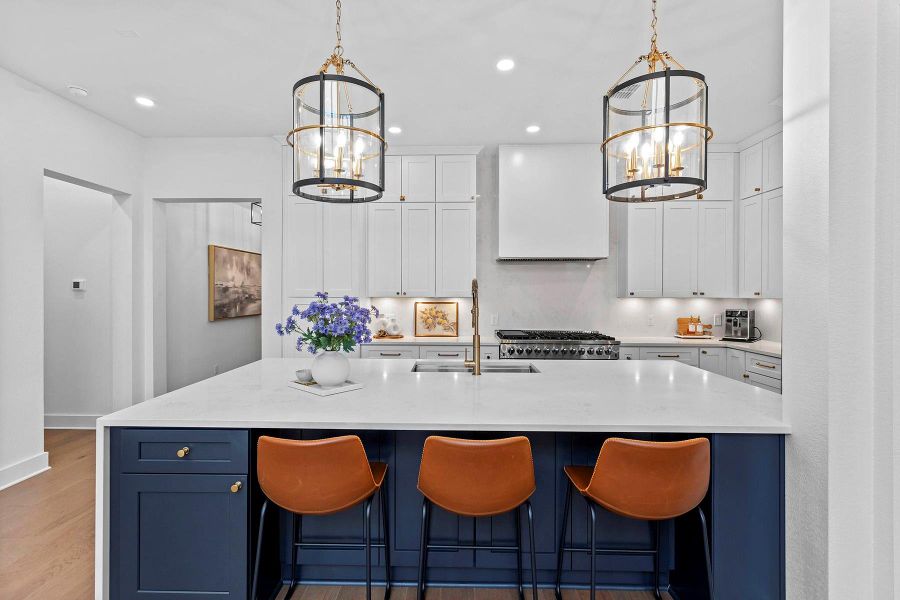 Kitchen with a kitchen island with sink, ventilation hood, and an inviting chandelier