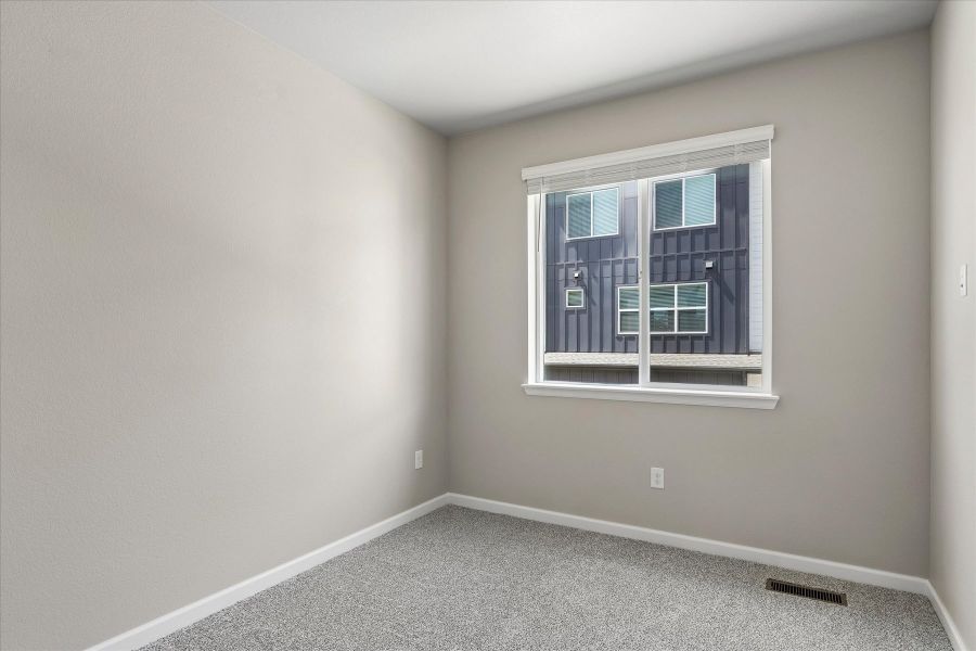 A room with a window and a rug in it.