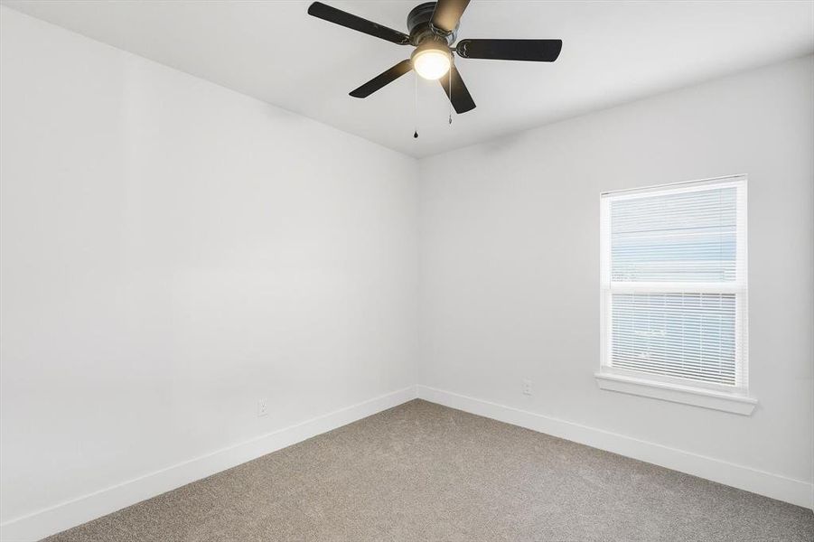 Unfurnished room featuring carpet and ceiling fan