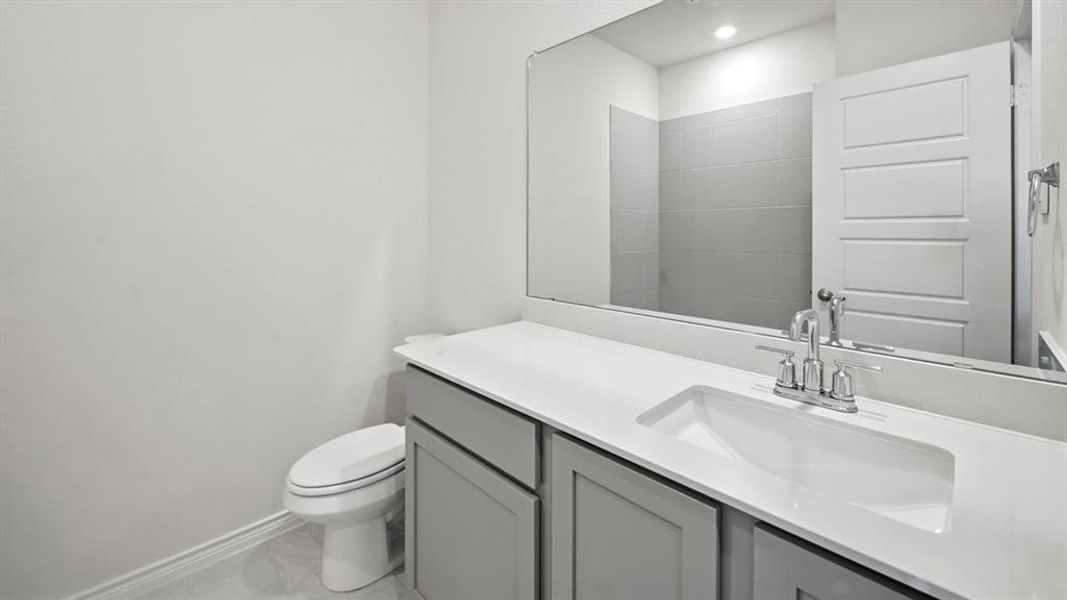 Contemporary vanity featuring a rectangular undermount sink, a white countertop, and gray shaker-style cabinetry