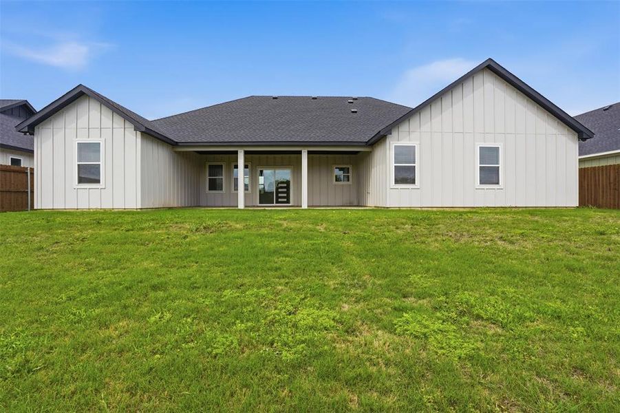 Expansive green lawn backing a contemporary residence with board-and-batten siding