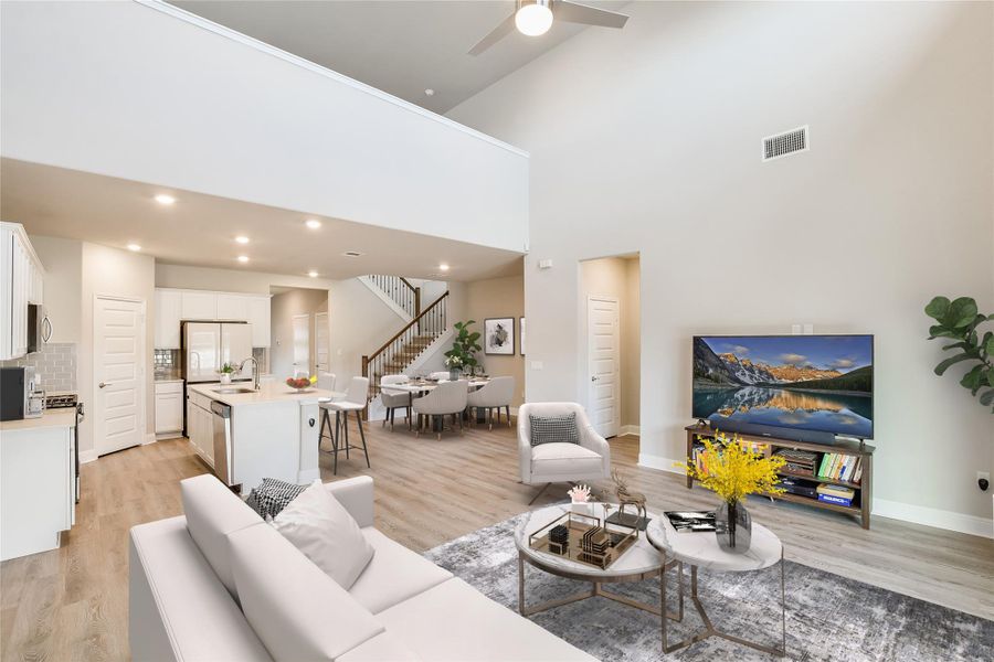 Living room featuring stairs, visible vents, light wood-style flooring, and recessed lighting