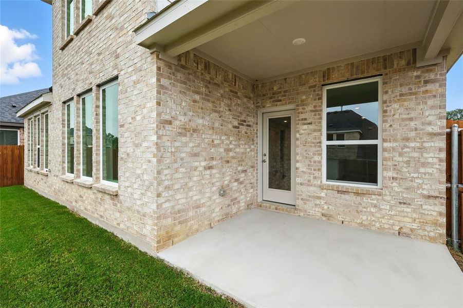 Property entrance featuring a patio area and brick siding Property entrance featuring a patio area and brick siding