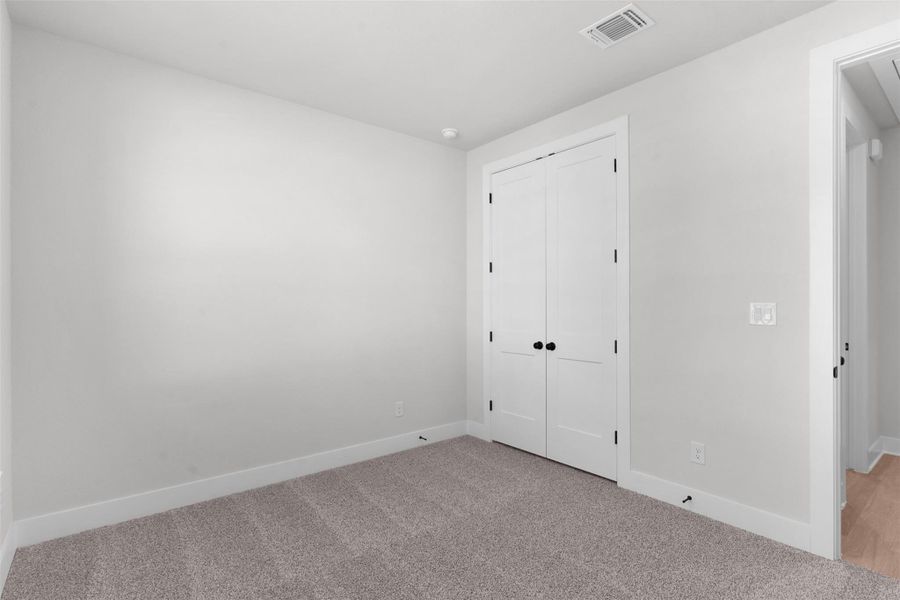 Unfurnished bedroom with carpet and a closet Unfurnished bedroom with carpet and a closet