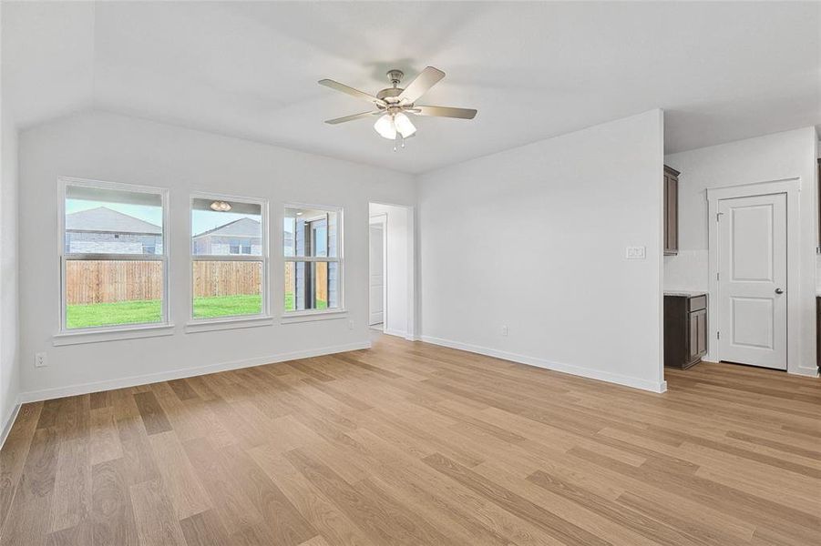 Unfurnished living room with vaulted ceiling, light hardwood / wood-style flooring, and ceiling fan