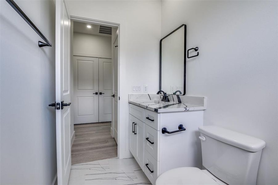 Bathroom featuring vanity, marble look tile flooring, and recessed lighting Bathroom featuring vanity, marble look tile flooring, and recessed lighting