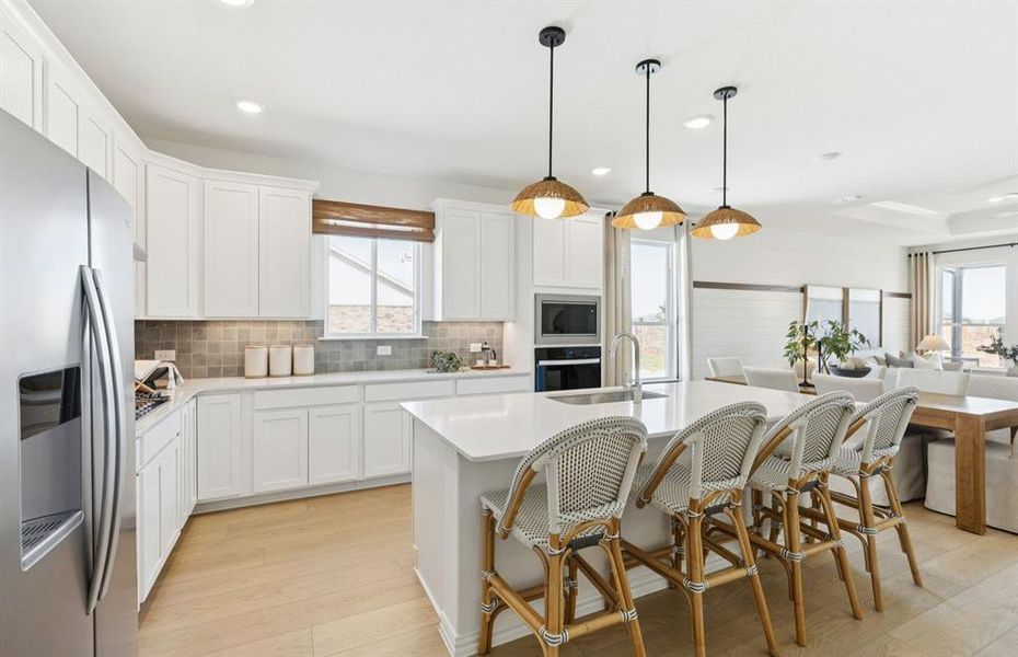 Large island overlooking gathering room and dining areas *Model Representation*