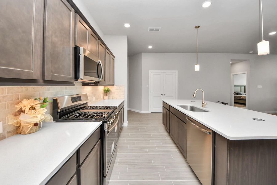 Beautiful kitchen with quartz counters and premium appliances.  Upgrade includes under cabinets lights, lighting in all closets/pantry and extra celling lighting throughout the home.