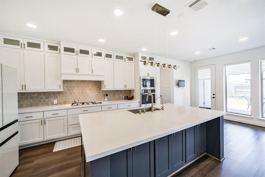 The center island, a cozy breakfast nook, and a door leading to the outdoor patio. The center island, a cozy breakfast nook, and a door leading to the outdoor patio.
