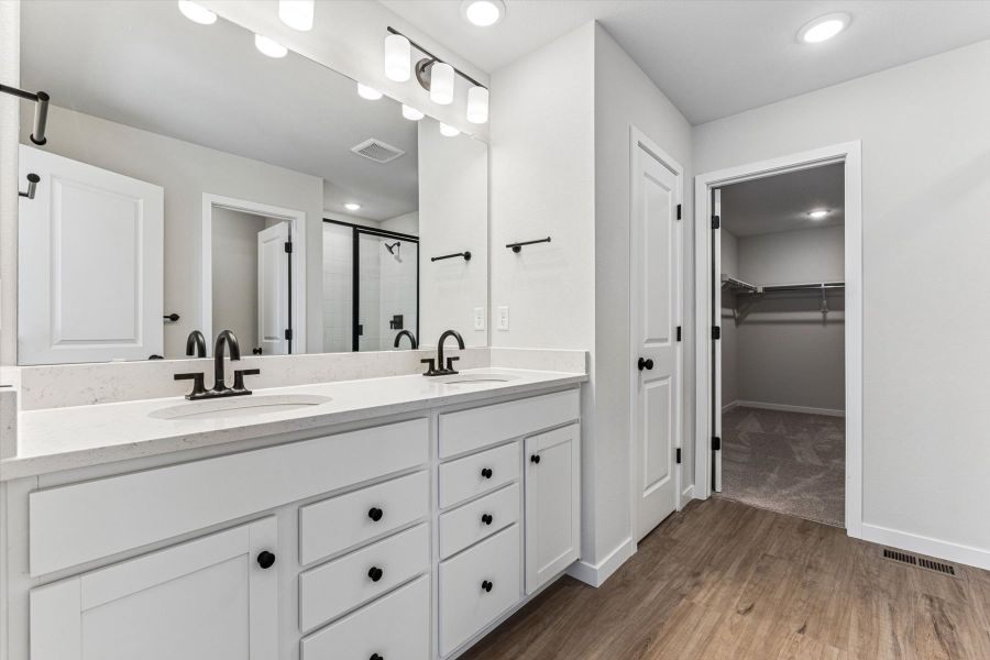 A bathroom with white cabinets.